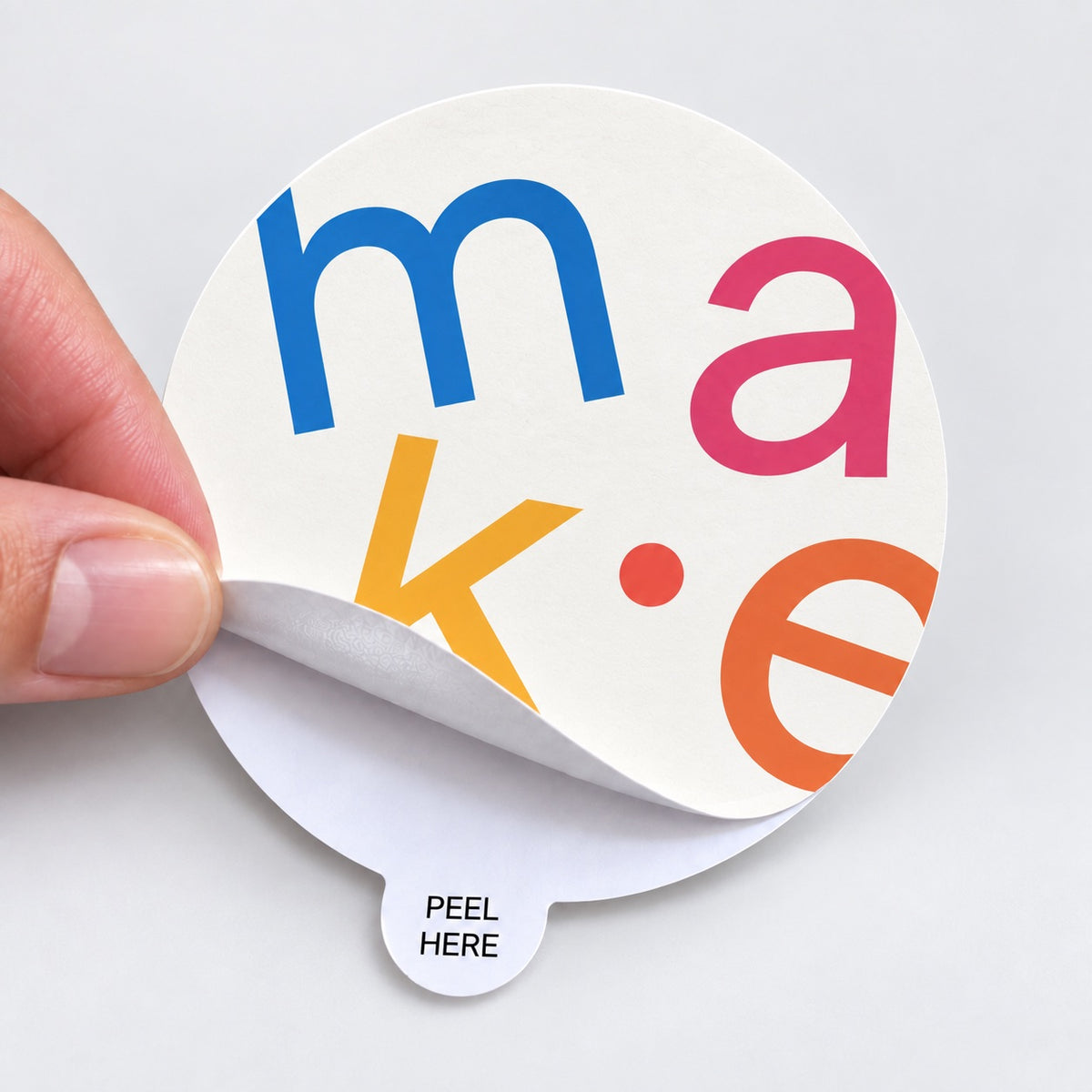 Close-up of a colorful custom round sticker with an easy-peel tab for quick backing removal.