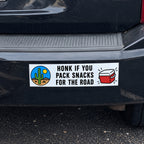 Funny custom bumper sticker reading Honk If You Pack Snacks for the Road on a black SUV.