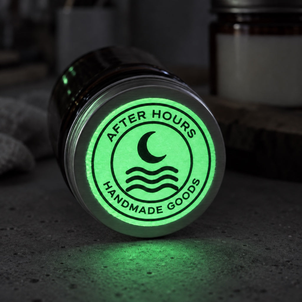 Round custom glow-in-the-dark logo sticker reading After Hours Handmade Goods on the bottom of a metal tumbler.