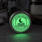 Round custom glow-in-the-dark logo sticker reading After Hours Handmade Goods on the bottom of a metal tumbler.