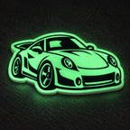 Custom die-cut sports car sticker glowing bright green in the dark.