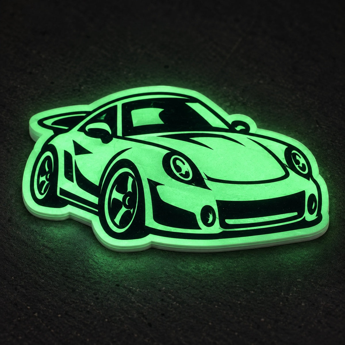 Custom die-cut sports car sticker glowing bright green in the dark.