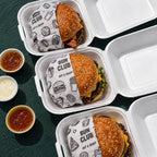 Custom printed food wrapping paper used with burger takeout boxes for branded restaurant packaging