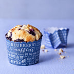 Custom printed paper bakery cup holding a blueberry muffin with colorful branded wrapper detail