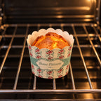Custom printed paper bakery cup with warm oven baked muffin and branded patisserie wrapper design
