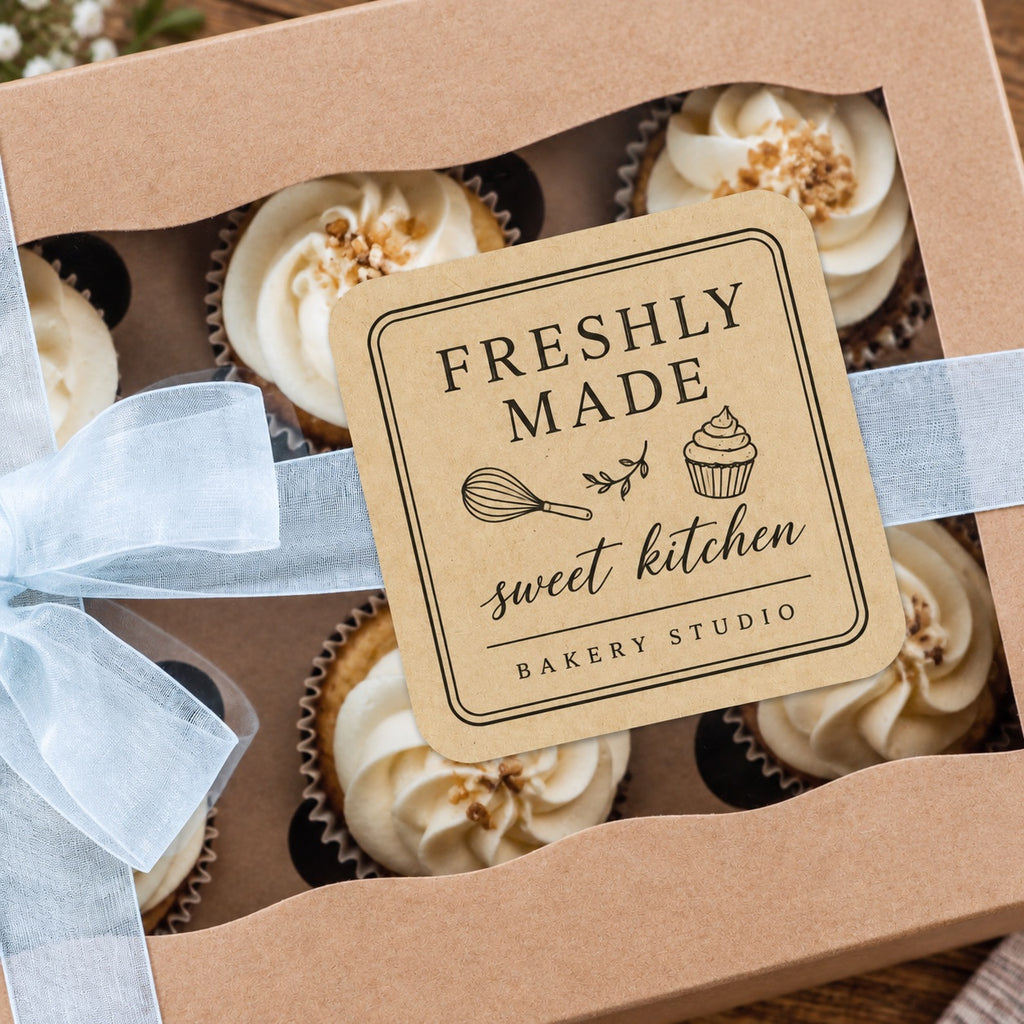 Custom kraft rounded corner bakery label applied to a ribbon-wrapped cupcake gift box.