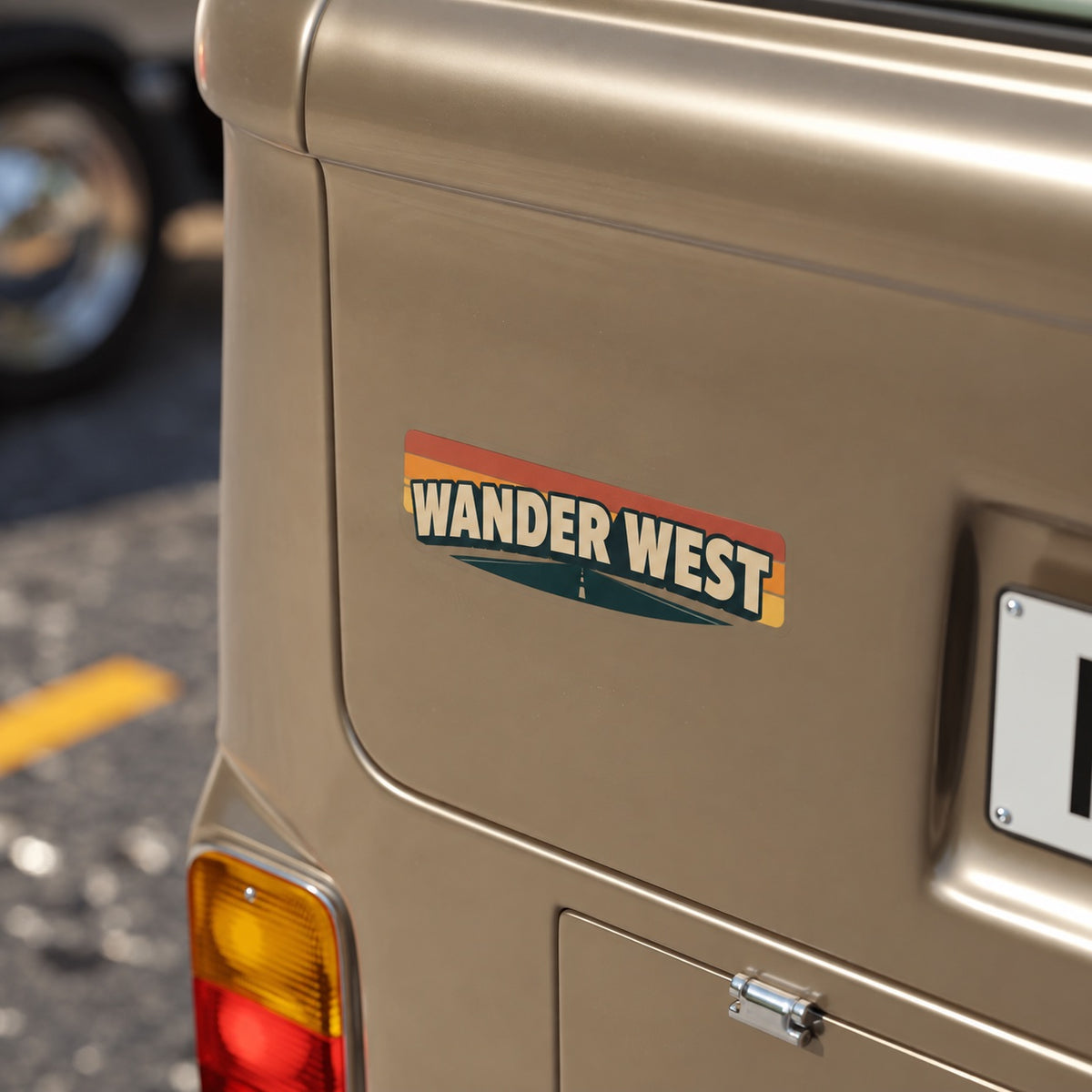 Custom vinyl bumper sticker reading Wander West applied to the rear of a brown vehicle.
